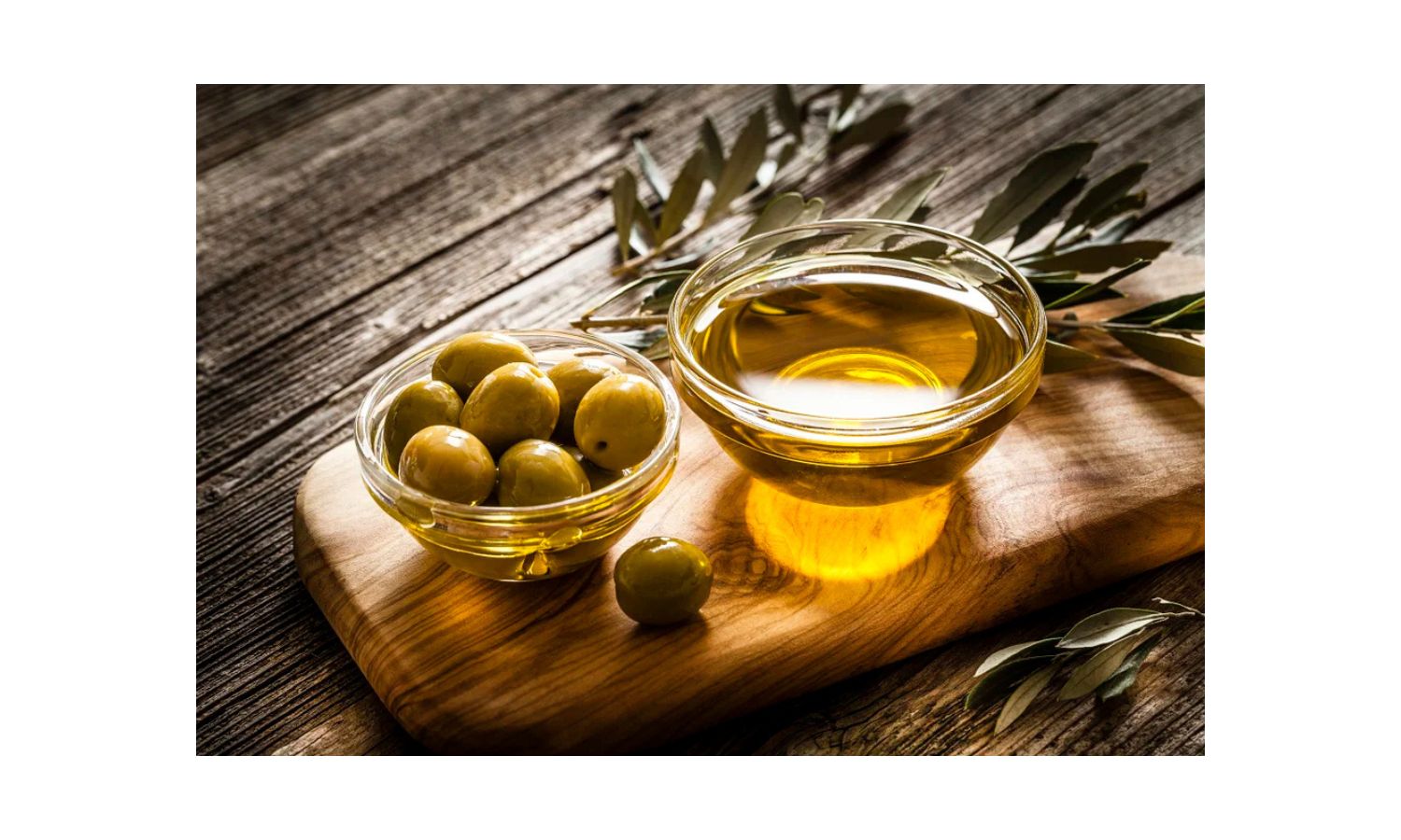 Azeite de oliva extra virgem em tigela com pães e azeitonas